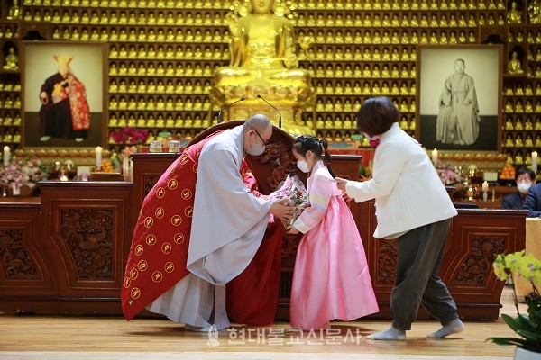 삼광사 주지 영제 스님이 화동에게 꽃을 받고 있다.