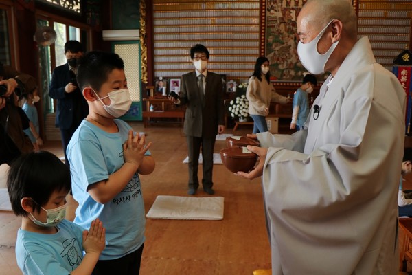 약사사 주지 범해 스님(조계종 제8대 포교원장)이 어린이법회 아이들에게 발우저금통을 나눠주고 있다.
