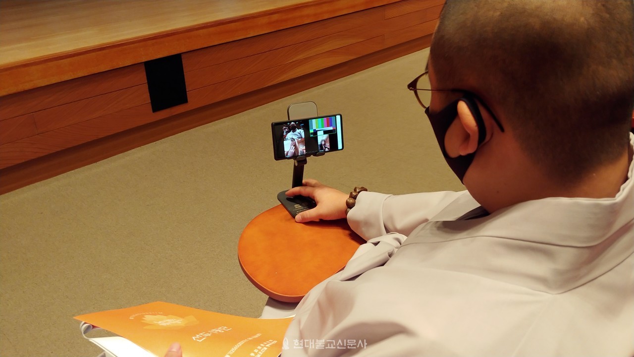 구룡사 총무 성륜 스님이 줌 화면을 조정하고 있다.