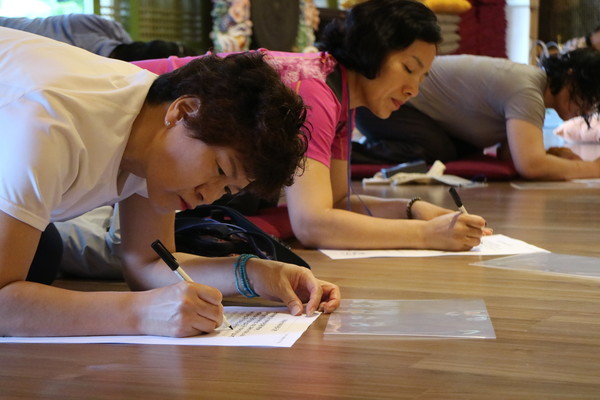 중대사자암에서 수행의 일환으로 〈반야심경〉 사경을 정성스럽게 하고 있는 불자들의 모습.