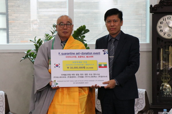 국제불교연합 NGO대표 현오 스님(사진 왼쪽)이 딴 타익 준장에게 싱그라미 KF94 마스크를 전달하고 있다.