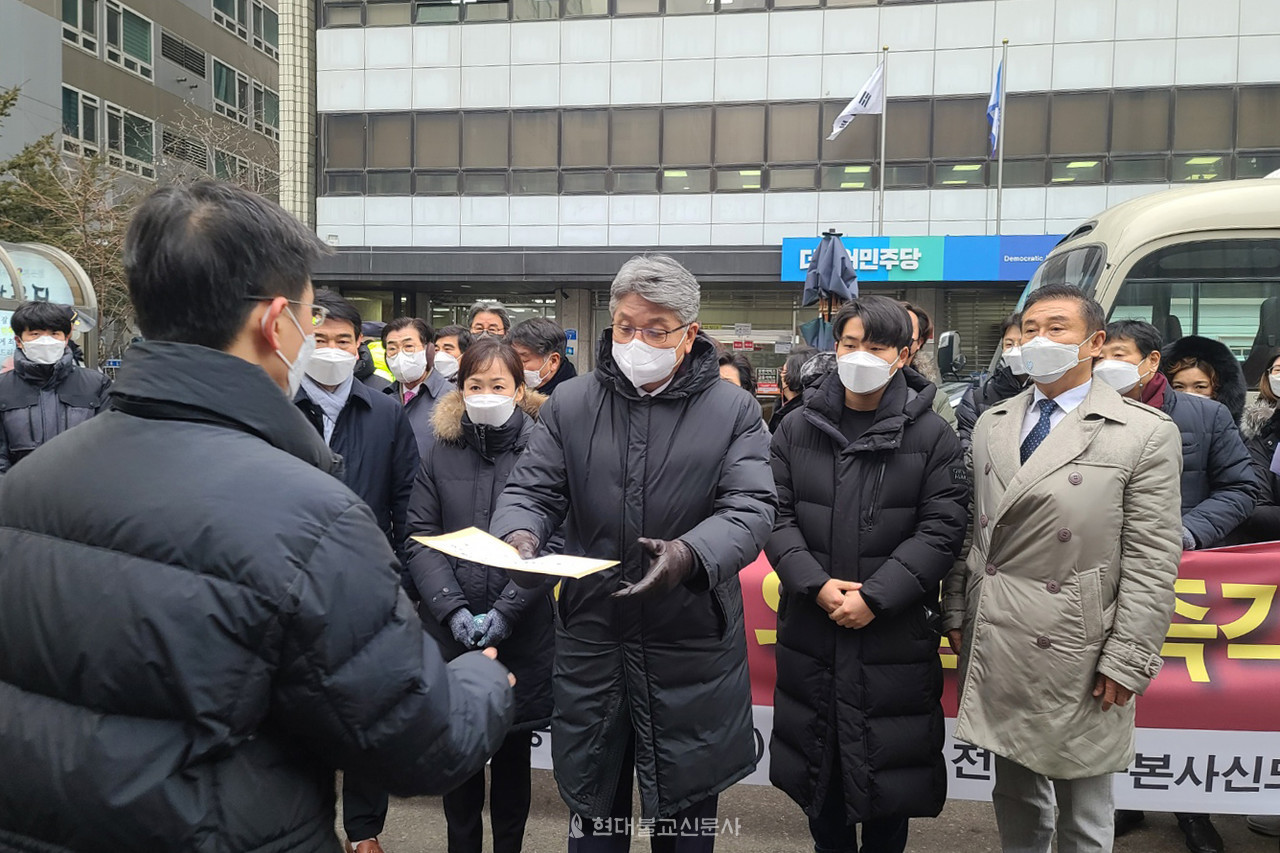 주윤식 조계종 중앙신도회장이 민주당 당직자에게 항의서한을 전달하고 있다.