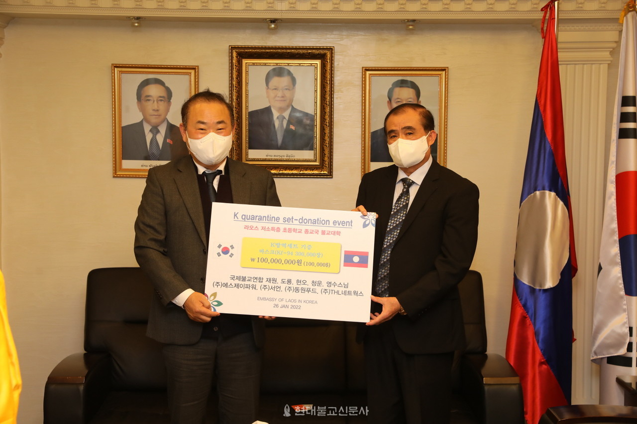 신항철 에스제이파워 대표가 라오스 대사에게 마스크 증서를 전달하고 있다.