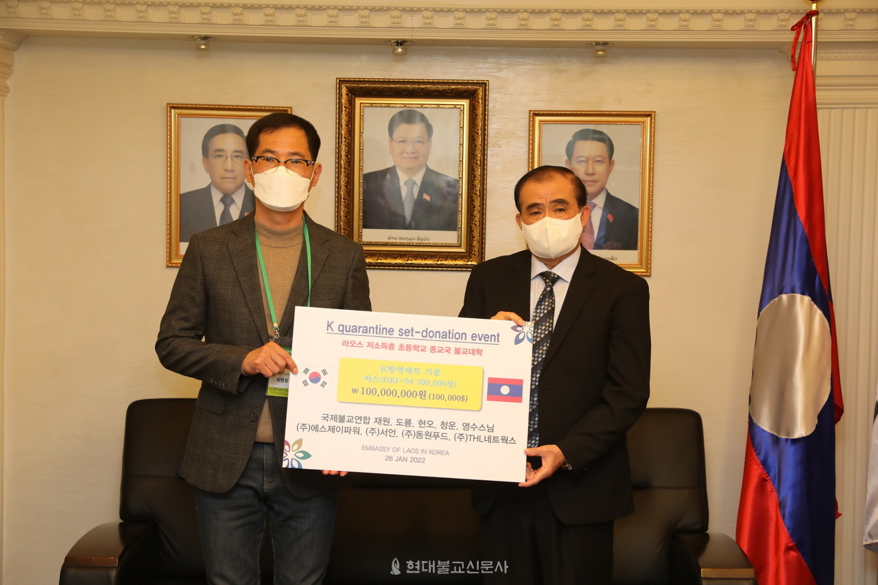 최병환 동원푸드 대표가 라오스 대사에게 마스크 증서를 전달하고 있다.