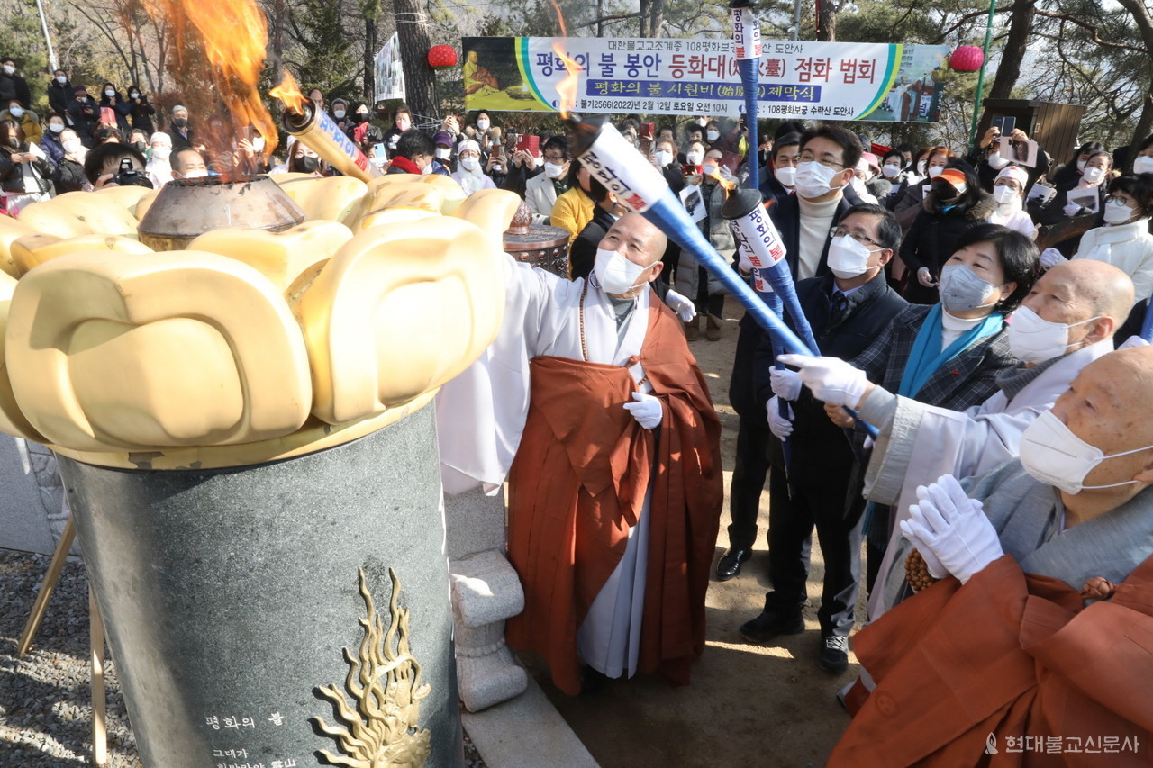 사부대중이 한반도 평화를 기원하며 평화의불 등화대에 점화하고 있다.