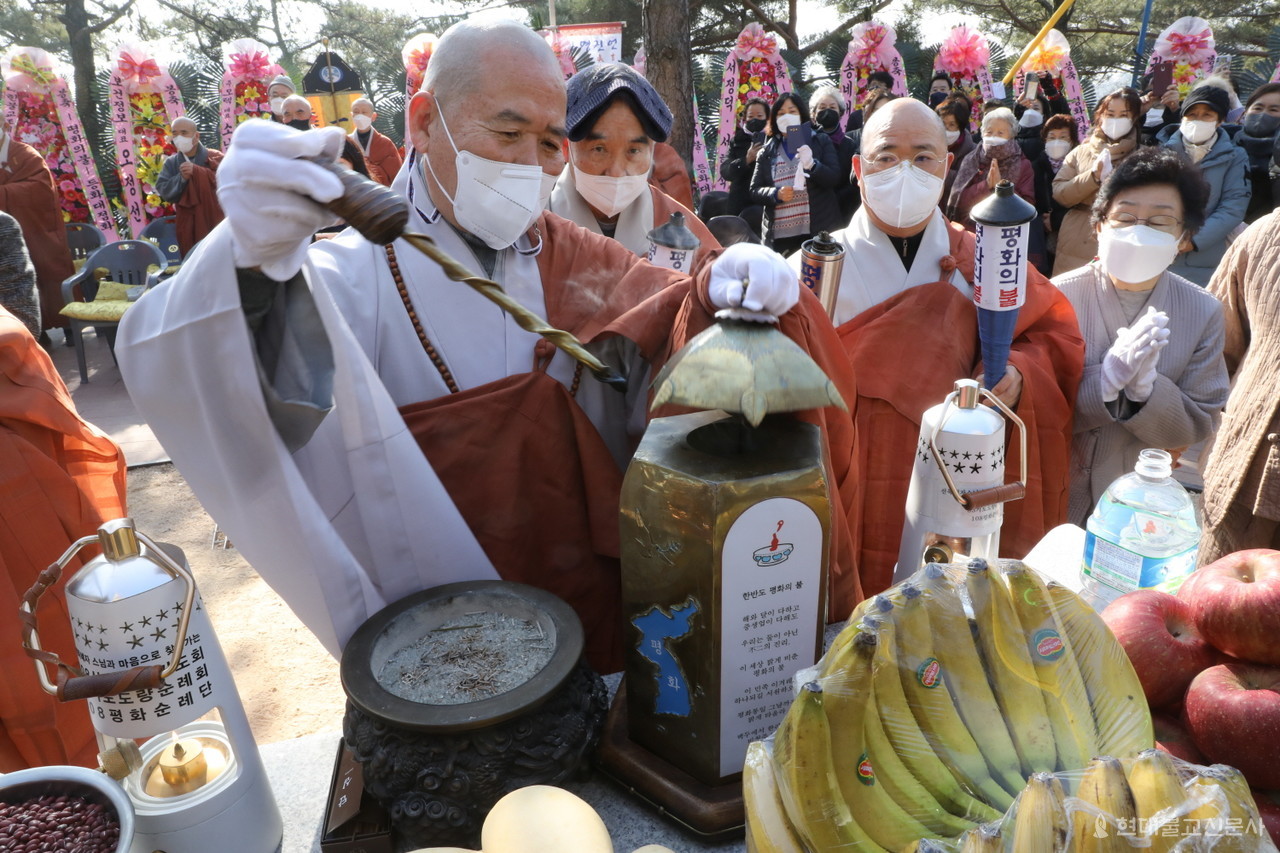 선묵 혜자 스님이 평화의불을 보관한 등에서 평화의불을 옮기고 있다.