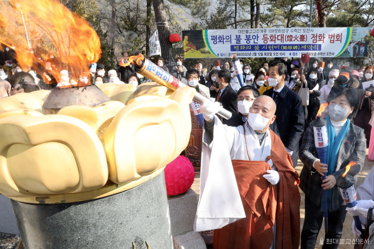 선묵 혜자 스님이 도안사 등화대에 평화의불을 점화하고 있다.