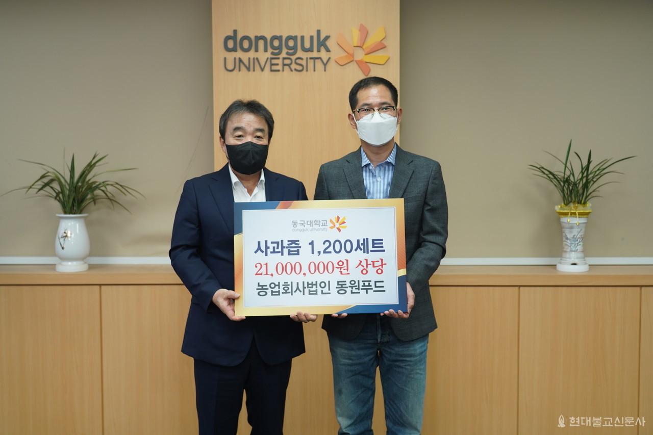 최병환 동원푸드 대표가 9월 15일 윤성이 동국대 총장에게 사과즙 1200세트를 전달하고 있다. 