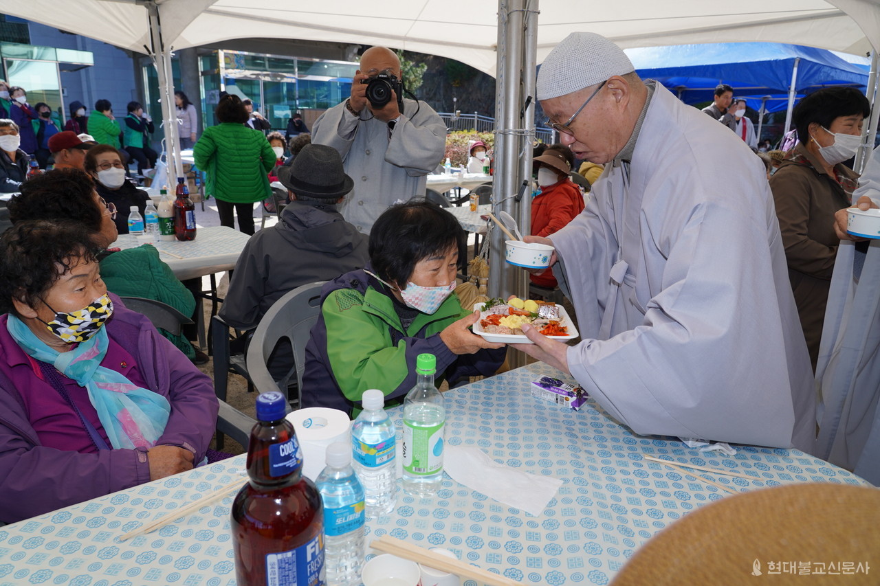 청련사 주지 상진 스님이 지역어르신들에게 직접 정성스럽게 마련한 점심식사를 전달하고 있다.