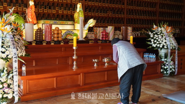 서울 조계사 대웅전에 마련된 합동분향소에서 한 불자가 향을 올리고 합장하고 있다. 