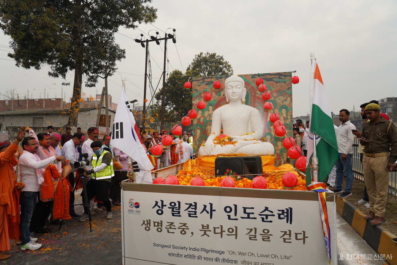환영 나온 쿠시나가르 인도주민들이 큰부처님상에 꽃잎을 뿌리고 있다.