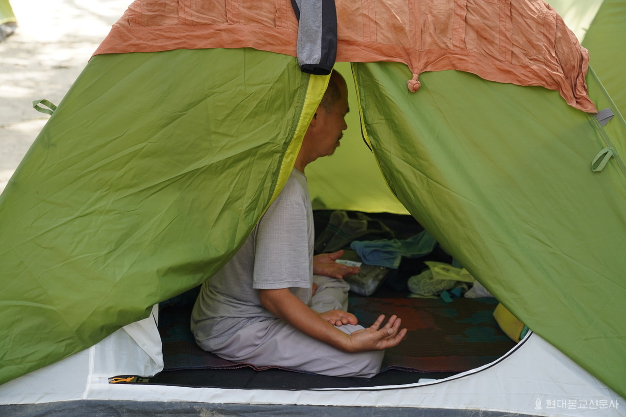 한낮 텐트 안 온도는 40도에 육박한다. 비오듯이 내리는 땀에도 꿋꿋하게 매일 좌선을 하고 있는 5조 시관 스님. 순례 한달을 넘은 3월 10일 각자 불교중흥의 서원으로 가행정진하고 있다.