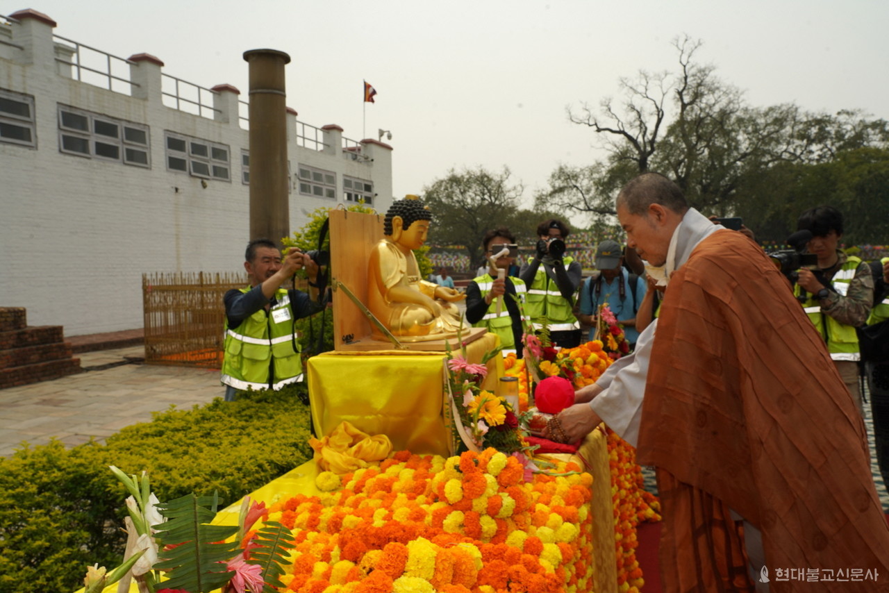 상월결사 회주 자승 스님이 마야데비사원 앞에 모셔진 부처님상에 연등을 공양 올리고 있다. 부처님 뒤로 부처님 탄생을 찬탄한 기원전 3세기 아소카왕 석주가 자리하고 있다.