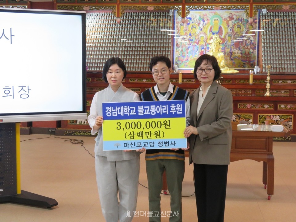 김선정 정법사 신도회장(사진 왼쪽)이 정법사 장학위원회에서 마련한 운영지원금을 전달하고 있다