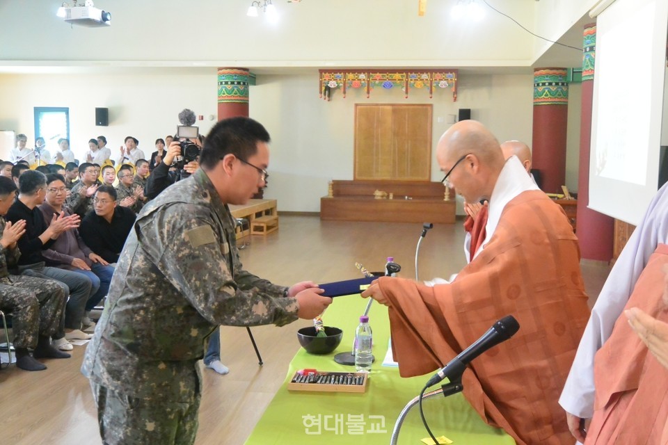 경우스님이 수계장병 대표에게 수계첩을 전달하고 있다