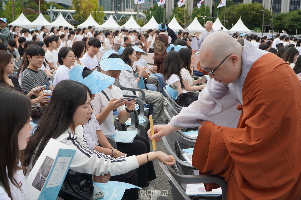 조계종이 9월 28일 서울 광화문광장에서 개최한 ‘2024 국제선명상대회 불교도대법회’에서 3만 5000여 불자를 대상으로 ‘국민오계 수계법회’를 봉행했다. 팔을 걷어 올려 수계법사스님에게 연비를 받은 불자들은 자신의 마음 평안과 모두의 평화를 위해 국민오계를 잘 받들어 지킬 것을 다짐했다. 사진출처=현대불교신문 DB