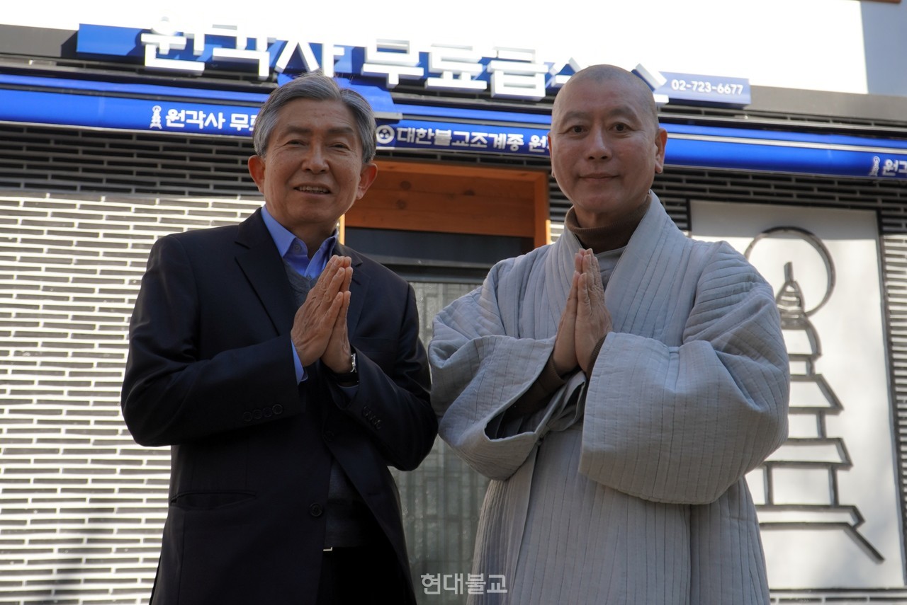 원각사 무료급식소에서 16년째 배식봉사를 하고 있는 민일영 전 대법관(사진 왼쪽)과 사회복지법인 원각 대표 원경 스님이 지난 2월, 새롭게 단장해 문을 연 원각사 무료급식소 앞에서 환하게 웃고 있다. 이들은 “부처님 가르침은 곧 실천이고, 배고픈 이들에게 따뜻한 한 끼를 제공하는 일이 세상에서 가장 의미있는 일 중 하나”라고 입을 모았다.