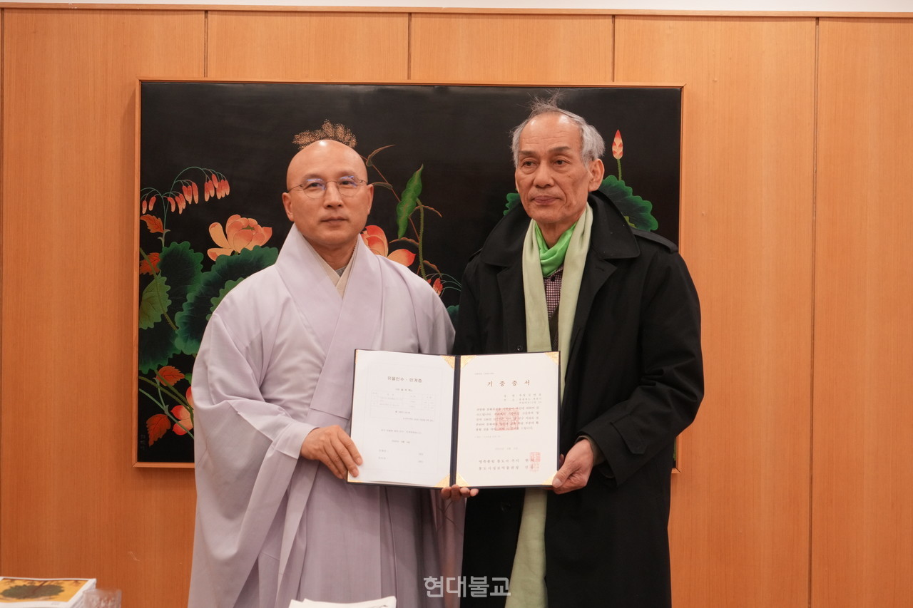 지난 3월 4일 영축총림 통도사 주지실에서 열린 성보문화유산 기증식에서 주지 현덕 스님이 김연호 회장에게 기증 증서를 전달하고 있다.