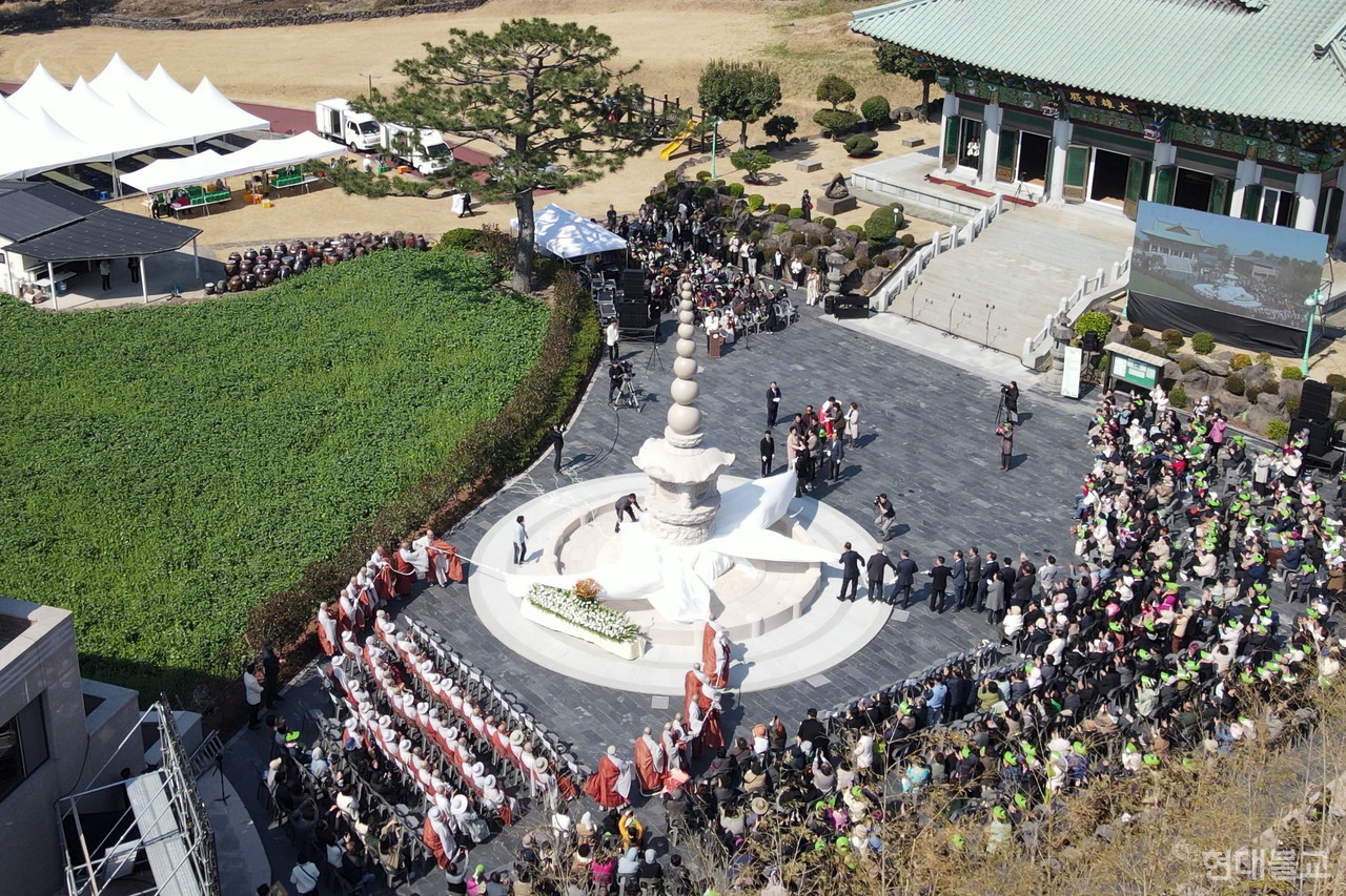 비구 비구니 우바이 우바새 사부대중이 각자 맡은 위치에서 구정탑을 제막하고 있다.