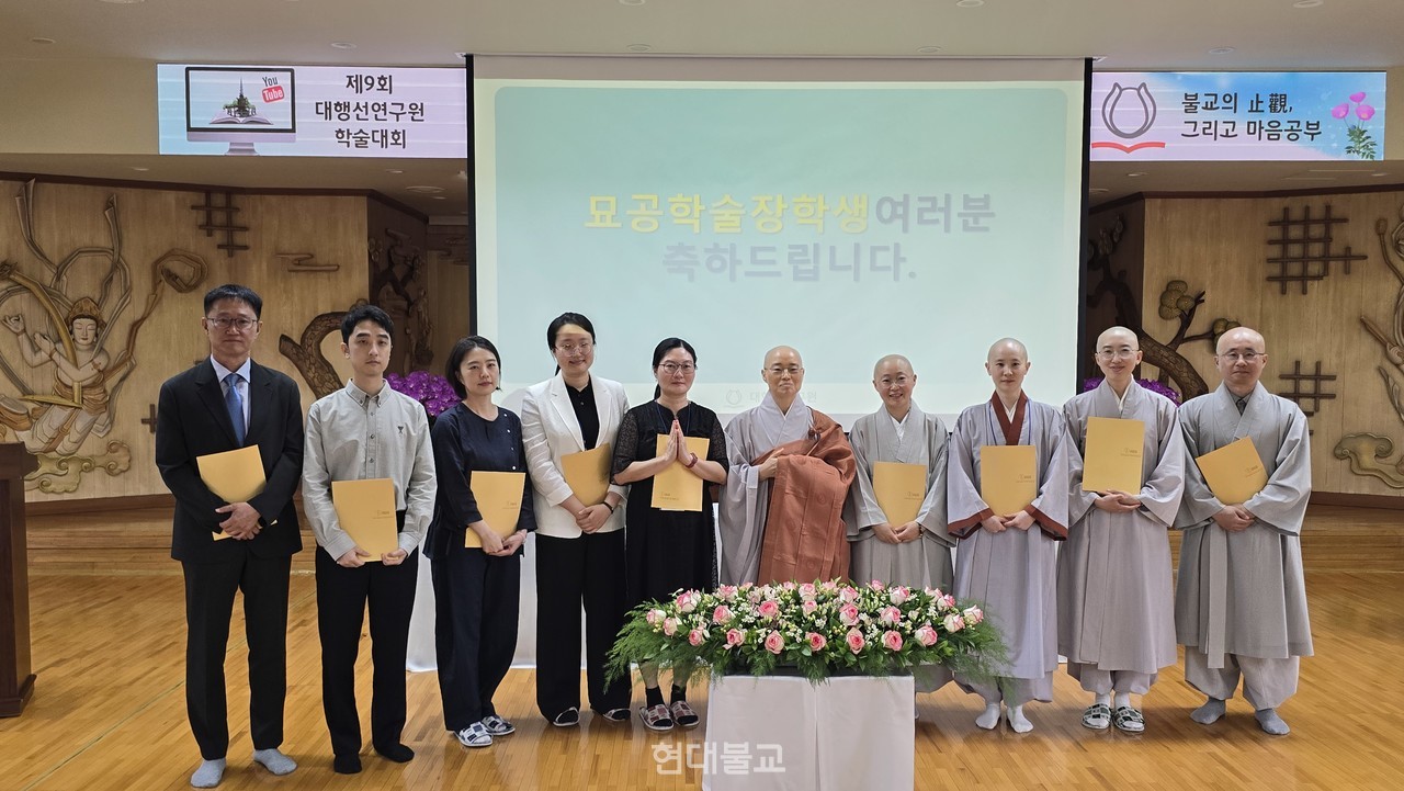 장학증서를 받은 묘공학술장학생들과 한마음선원 안양본원 주지 혜솔 스님(시진 가운데)이 기념촬영을 하고 있다. 