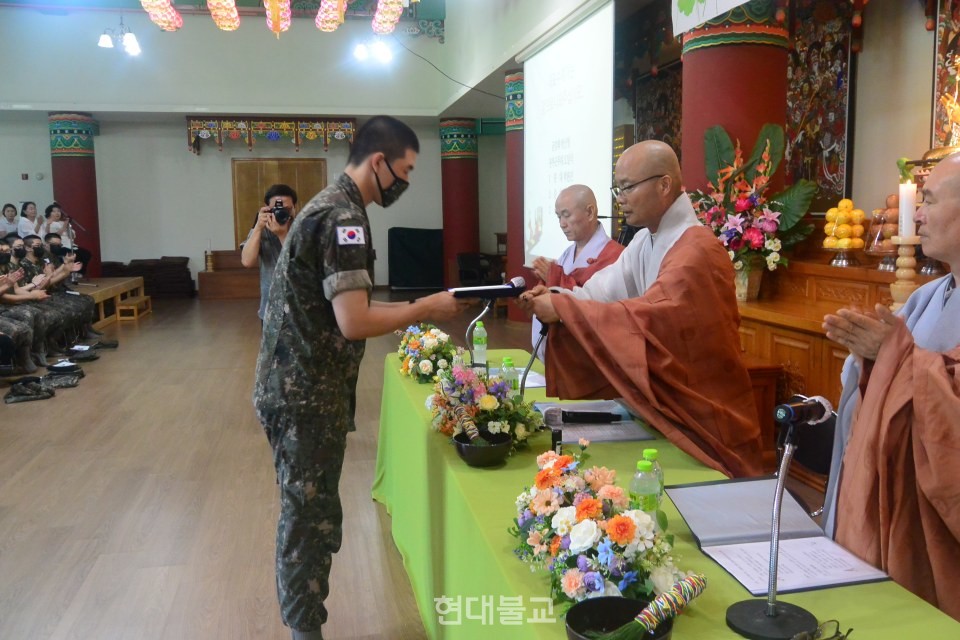 경우스님이 수계자 대표에게 수계첩과 단주를 전달하고 있다