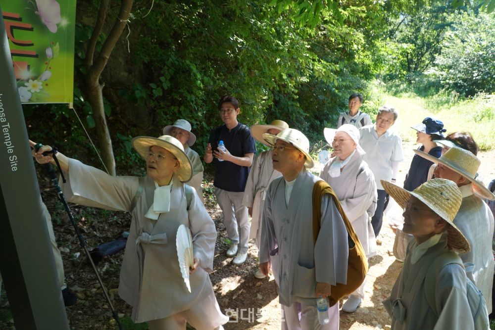 새로 세워진 종합안내판을 보고 있는 스님들.