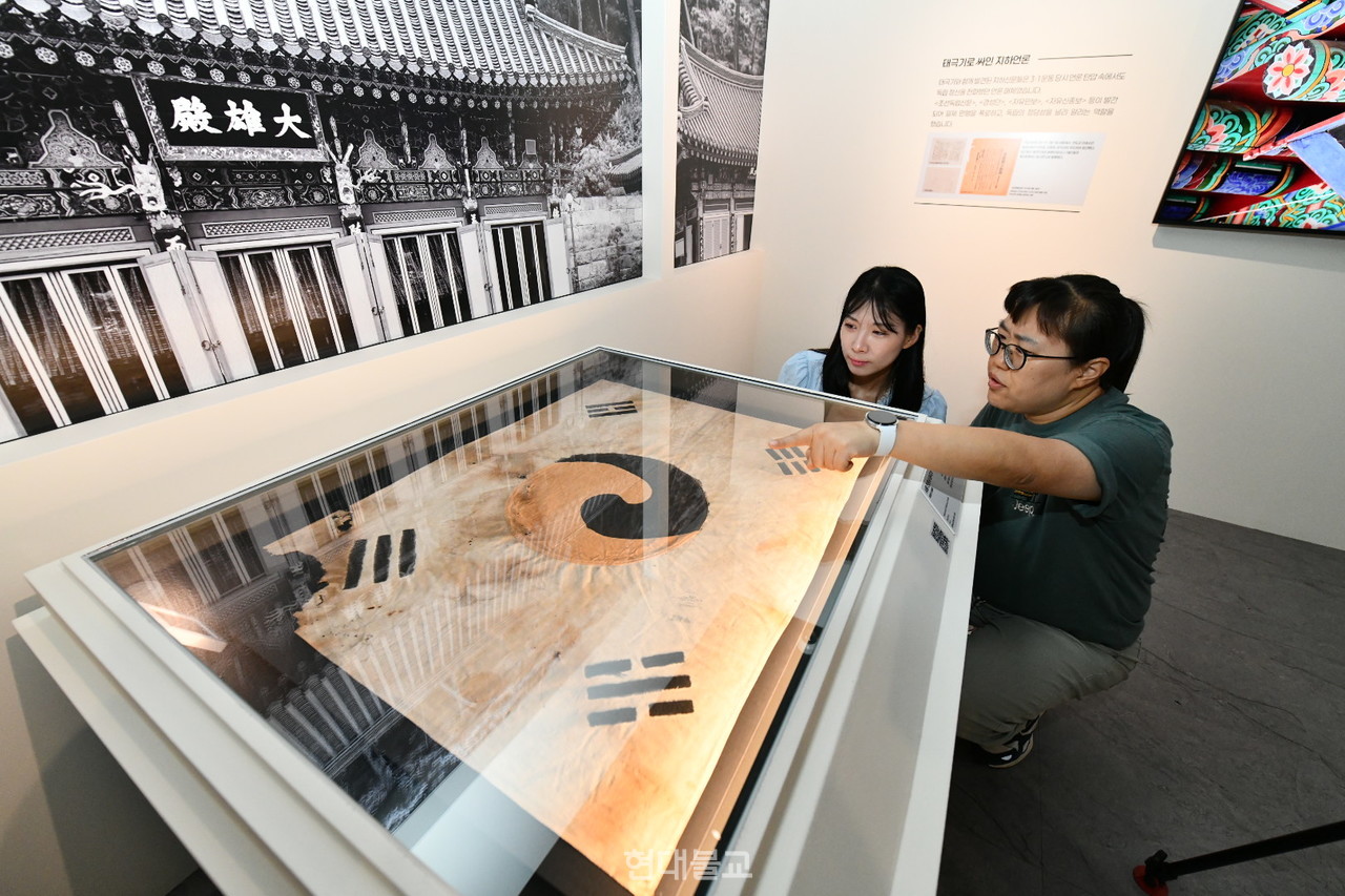 10월 12일까지 덕수궁 돈덕전에서 열리는 특별전 ‘빛을 담은 항일유산’에서  전시되는 '서울 진관사 태극기'를 관람객이 살펴보고 있다.  사진=국가유산청