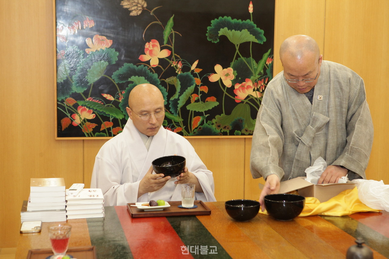 현덕 스님이 총무부장 성웅 스님이 직접 제작해 선물한 도자기 발우를 보고 있다 .