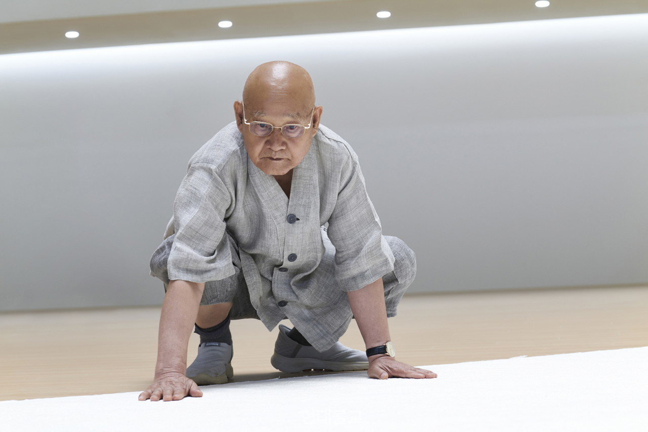 조계종 종정 중봉 성파 대종사는 오는 9월 4일부터 11월 2일까지 청주에서 열리는 ‘2025 청주공예비엔날레’에 참여해 특별전 ‘성파선예전-명명백백(明明白白)’을 대중에게 선보인다. 사진은 성파 스님이 길이 100m 대작인 '명명백백'을 살펴보는 모습. 사진 제공=청주국제공예비엔날레 조직위원회