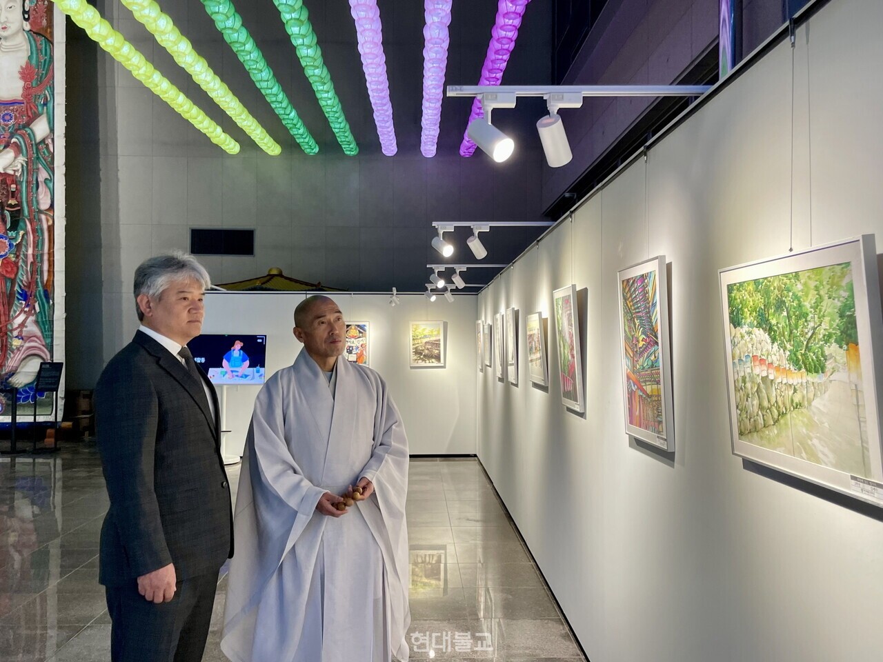 관장 정오 스님과 김해관 부산예술고등학교 교장이 전시를 관람하고 있다.