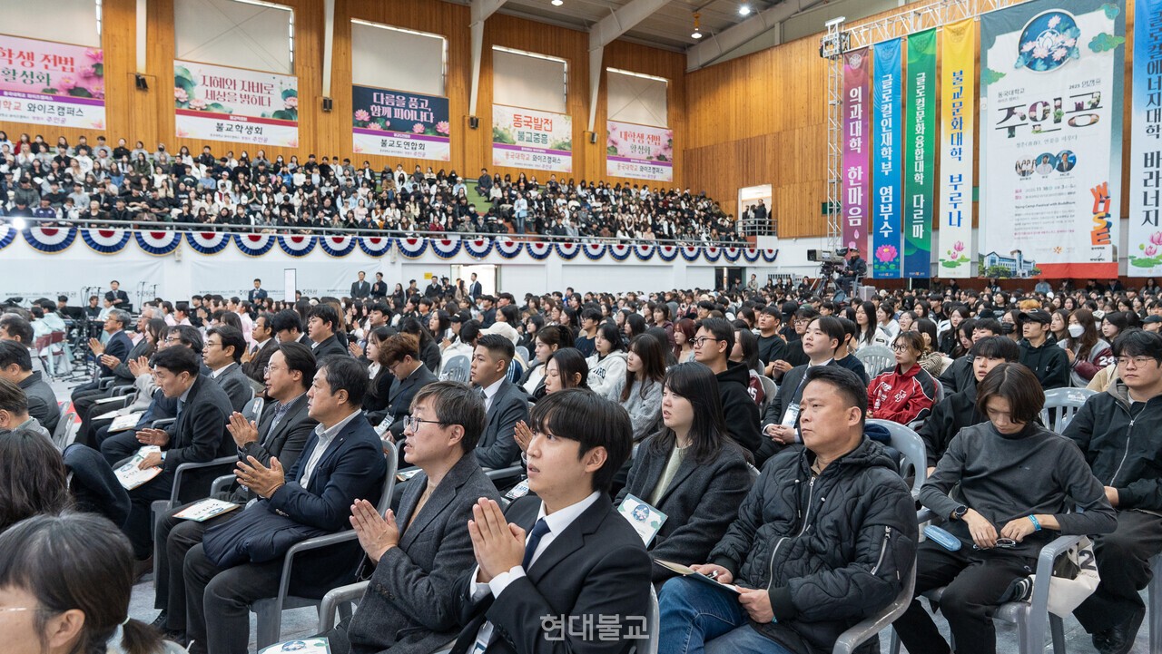 문무관을 가득 메운 학생들이 수계법회에 참석해 합장하고 있다.