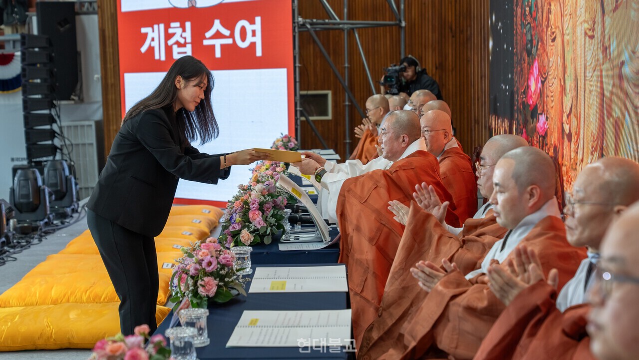 학생 대표가 스님에게 계첩을 수여받고 있다.