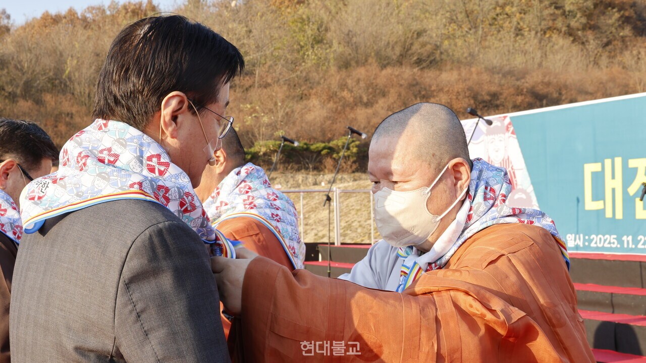 수덕사 주지 도신 스님이 장년 대표에게 서원건을 걸어주고 있다.