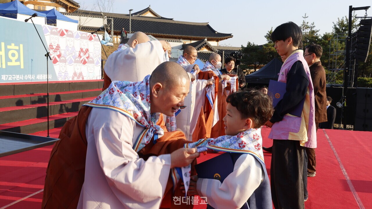 조계종 포교부장 정무 스님이 어린이 대표에게 서원건을 걸어주고 있다.