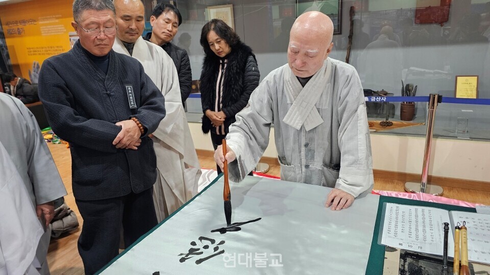 전 총무원장 설정스님이 만장에 글을 쓰고 있다