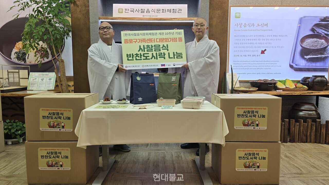 한국불교문화사업단 사무국장 상원 스님(사진 오른쪽)이 조계종사회복지재단 사무처장 덕운 스님(사진 왼쪽)에 사찰음식 반찬 도시락을 전달하고 있다. 