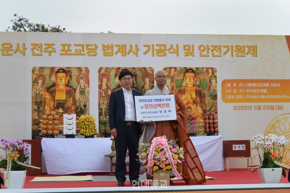 임종혁 전 선운사 신도회장이 불사기금을 선운사 주지 경우 스님에게 전달하고 있다