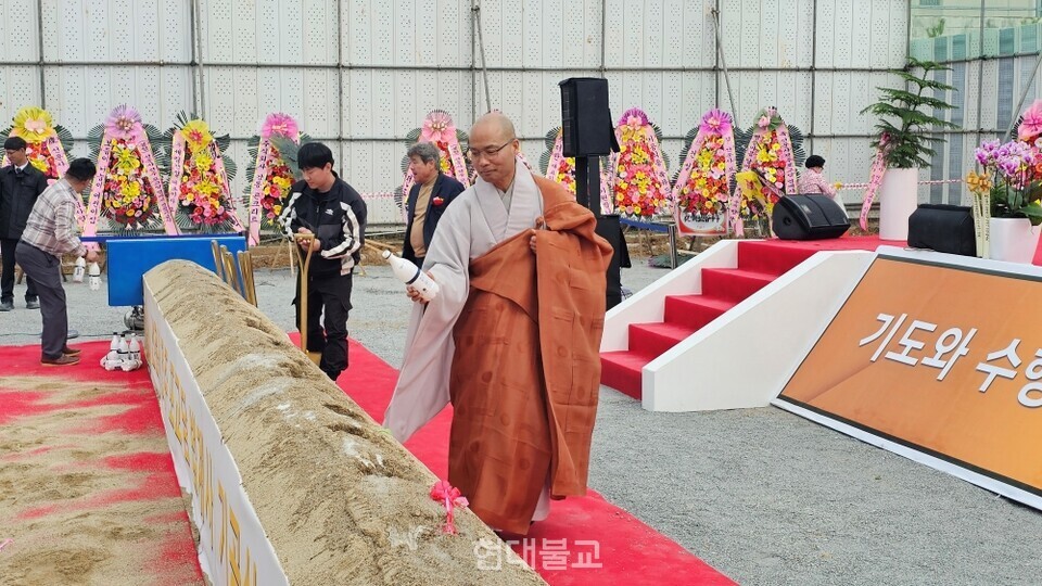 선운사 주지 경우 스님이 법계사 공사의 안전을 기원하며 막걸리를 뿌리고 있다