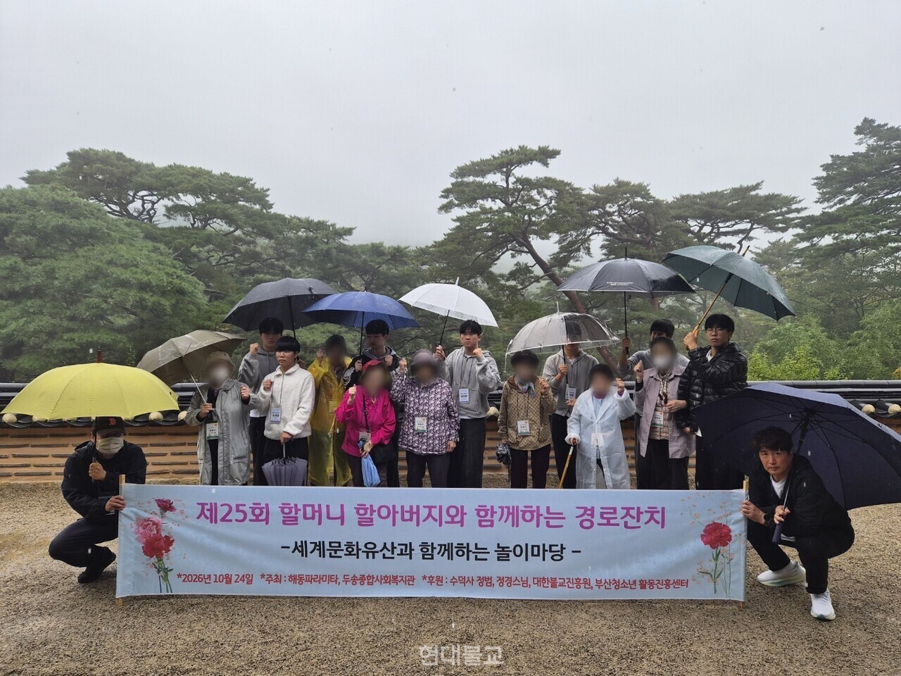 '제25회 경로잔치' 현수막을 들고 단체 기념 촬영을 하는 해동고 학생들과 어르신들.